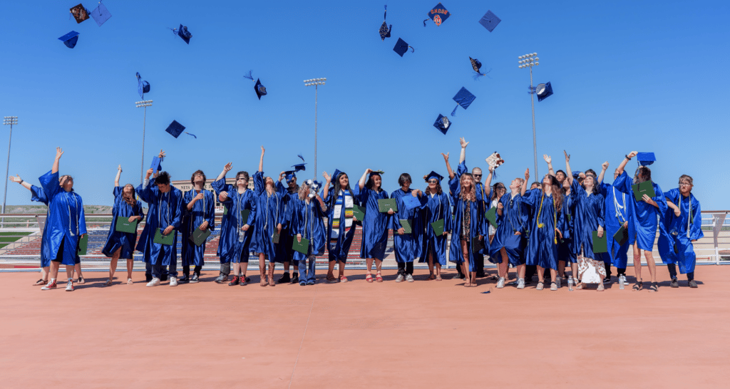 Row of graduates tossing caps in the air