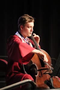 GOAL Graduate playing his cello at graduation ceremony. 