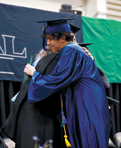 Graduate hugging staff member 